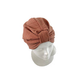 A dusty rose ribbed fabric turban hat displayed on a white mannequin head against a plain white background.
