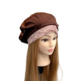 Mannequin head wearing a brown velvet beret on a white background