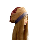 Mannequin head with a brown and maroon headband on a white background