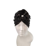 Black headband with floral design on a mannequin head against a white background