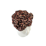 Leopard print headscarf on a white mannequin head against a white background