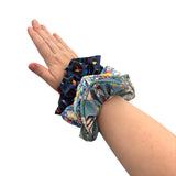 Hand wearing colorful scrunchies on a white background