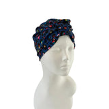 Navy headscarf with colorful patterns on a mannequin head against a white background
