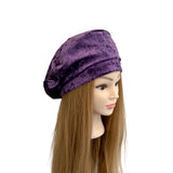 Purple velvet headscarf on a mannequin head with long brown hair against a white background