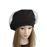 Black turban with a mesh veil on a mannequin head against a white background