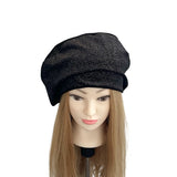 Black knit beret on a mannequin head with long blonde hair against a white background