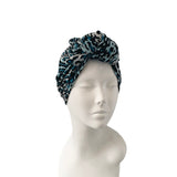 Blue and black patterned headscarf on a mannequin head against a white background