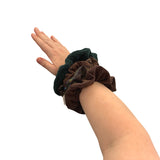 Hand wearing a wristlet with multiple scrunchies on a white background