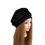 Black beret on a mannequin head with long brown hair against a white background