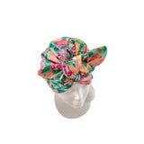 A multicolor floral turban headwrap displayed on a white mannequin head against a plain white background.