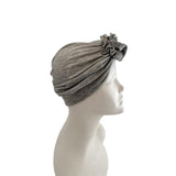 Gray headscarf with floral detail on a mannequin head against a white background