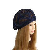 Navy blue lace headscarf on a mannequin head with long brown hair against a white background