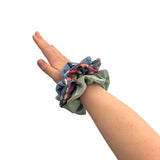 Hand wearing a colorful scrunchie on a white background