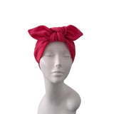 A bright red knotted fabric headwrap displayed on a matte gray mannequin bust against a plain white background.