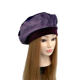 Purple beret on a mannequin head with long brown hair against a white background