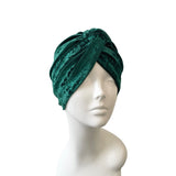 Green velvet turban on a mannequin head against a white background