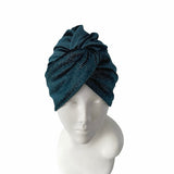 Blue knit turban on a mannequin head against a white background