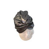 A metallic dark gray or black satin turban hat displayed on a white mannequin head against a plain white background.