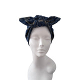 A dark navy blue fabric headwrap with a subtle gold pattern, styled on a white mannequin head against a plain white background.