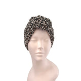 Leopard print turban on a mannequin head against a white background