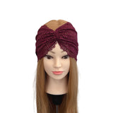 Mannequin head wearing a burgundy knitted turban with lace details on a white background