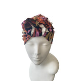 Colorful patterned headscarf on a mannequin head against a white background