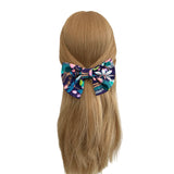 Floral patterned hair bow on a mannequin head with blonde hair against a white background