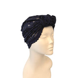 Navy blue lace headscarf on a mannequin head against a white background