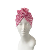 Pink patterned headscarf on a mannequin head against a white background