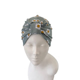 Gray headscarf with floral pattern on a mannequin head against a white background