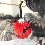 rust decorative item with black bat wings hanging from a branch.
