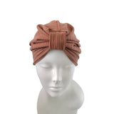 A ribbed knit turban-style headband in a muted dusty rose-brown color, displayed on a white mannequin head against a plain white background.