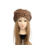 Mannequin head with long blonde hair wearing a leopard print beret on a white background