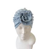 Light blue headband with a flower on a mannequin head against a white background