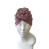 pink turban on a mannequin head against a white background