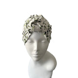 turban with leaf pattern on a mannequin head against a white background