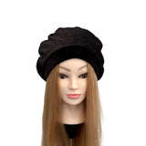 Black beret on a mannequin head with long blonde hair against a white background