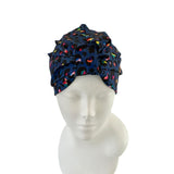 Navy blue headscarf with colorful patterns on a mannequin head against a white background