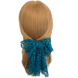 Mannequin head with teal lace hair accessory on a white background