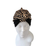 Turban with zebra pattern and black base on a mannequin head against a white background