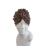 Leopard print headscarf on a mannequin head against a white background