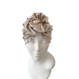 Gray patterned headscarf on a mannequin head against a white background