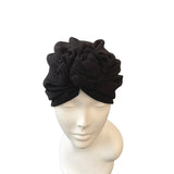 Black headband with floral design on a mannequin head against a white background