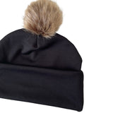 Black beanie with a fur pom-pom on a white background