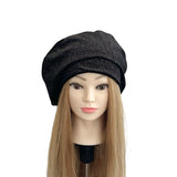 Black beret on a mannequin head with blonde hair against a white background