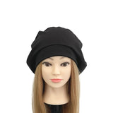 Mannequin head with long brown hair wearing a black beanie on a white background