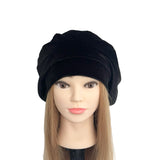 Black turban beret on a mannequin head with a white background