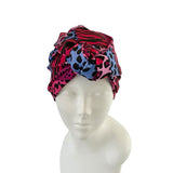 Colorful patterned headscarf on a mannequin head against a white background