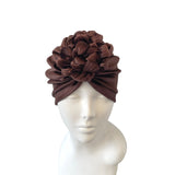 Brown headscarf with floral design on a mannequin head against a white background
