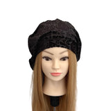 Black patterned headscarf on a mannequin head with long brown hair against a white background